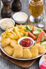 lunch with chicken nuggets, french fries, salad and beer