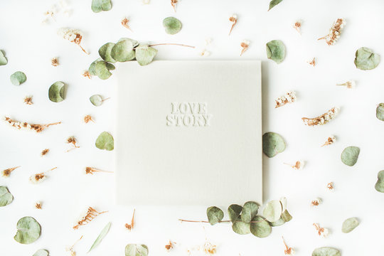white wedding or family photo album with words "love story", dry and fresh branches isolated on white background. flat lay, overhead view