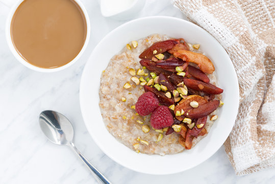 oatmeal with baked fruit and coffee with milk, top view