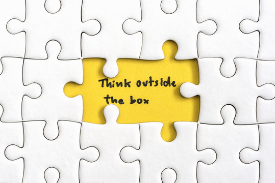 Jigsaw puzzle piece with two missing and hand writing letters word think outside the box Quotes business concept