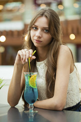 Young woman drinking cocktail in a cafe