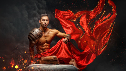 Muscular male in red waving fabric.