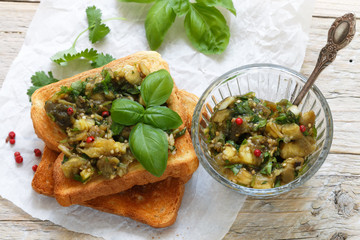 Baked eggplant on bread croutons with garlic, cilantro and Basil. Spicy snack. Selective focus