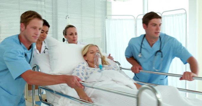 Medical team carrying patient on bed 