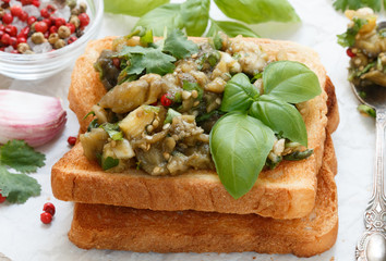 Baked eggplant on bread croutons with garlic, cilantro and Basil. Spicy snack. Selective focus