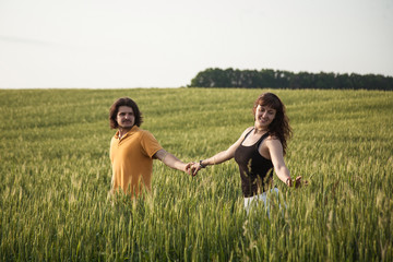 loving couple walking in a field.