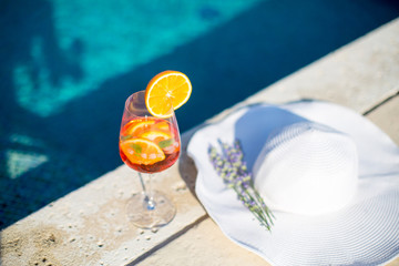 Orange cocktail near the pool at sunny day