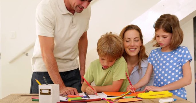 Happy parents and children drawing together at the table