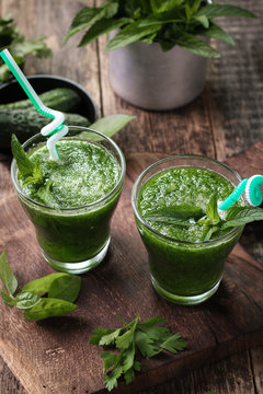 Fresh green smoothie with straws on a wooden table,healthy vegan food