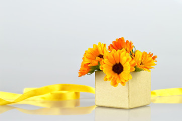 Flowers arranged in gift box on light background