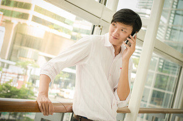Obraz na płótnie Canvas handsome asian man. businessman talking on mobile phone in moder