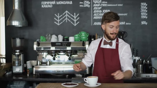 Young barista with cup of coffee