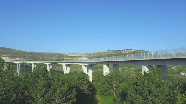 AERIAL: Flying towards big viaduct with cars and trucks