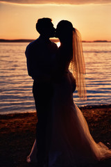 bride and groom together on a background sunset