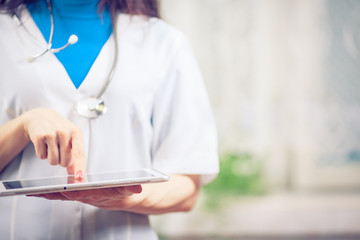 Doctor working on a digital tablet with copy space