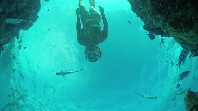 SLOW MOTION UNDERWATER: Woman snorkeling exotic reef with tropical fish