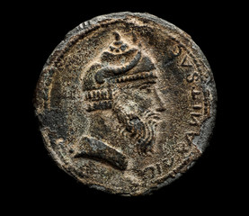 Ancient coin with head isolated on black
