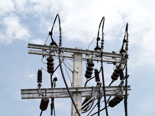 high voltage power lines connected to electrical insulators on steel beam