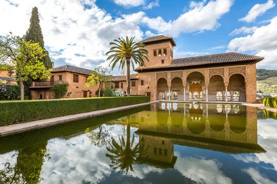 El Partal. A large central pond faces the arched portico behind which stands the Tower of the Ladies, inside the Alhambra of Granada, a World Heritage Site in Andalusia, Spain