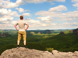 Man in trekking shorts on cliff of rock empire watch