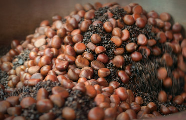 Chestnuts  View of roasting chestnuts inside pan. Chestnut snacks are famous and popular in Yaowarat Road, Bangkok, Thailand.