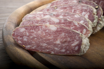 wooden cutting board with salami and bread