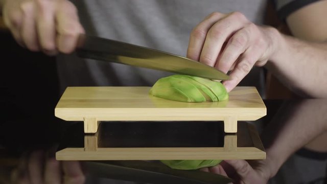 Chef cutting avocado for japanese sushi rolls