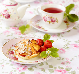 Cream puff cakes or profiterole filled with whipped cream, served with strawberries