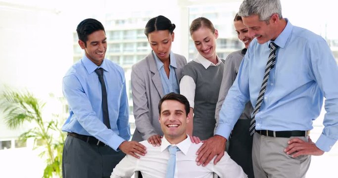 Business people smiling to their coworker on wheelchair 