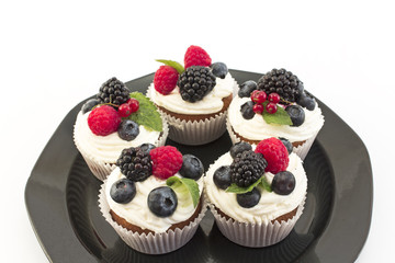 Elegant Cupcakes with Berries on the Black Plate