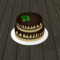 two-tier sponge chocolate cake with mint sprig on a plate. wood texture in the background.