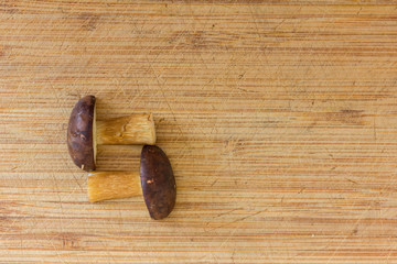 ein Pilz liegt in zwei Teile geschnitten auf einem Holzbrett