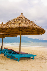 Palm shelter and sunbeds at China Beach in Da Nang