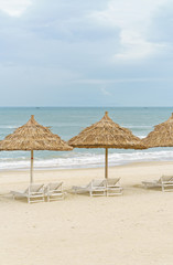 Palm shelter and sunbeds on China Beach in Da Nang