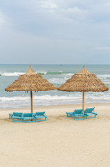 Palm shelters and sun beds in China Beach in Da Nang