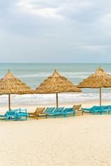 Palm shelters and sunbeds in China Beach in Da Nang