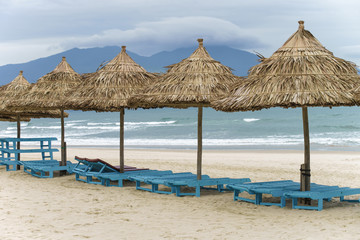 Palm shelters and sunbeds in the Beach in Da Nang