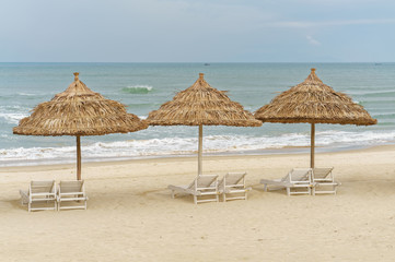 Palm shelters and sunbeds on China Beach in Da Nang