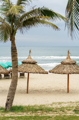 Palms shelter and sunbeds in China Beach in Da Nang