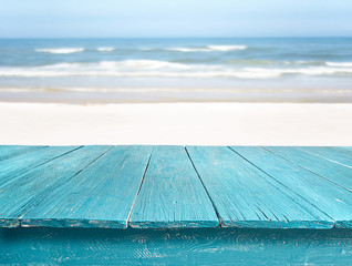 blue wooden table top against beach landscape