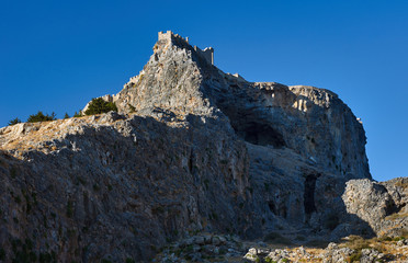Medieval fortifications on top of the rock in Lindos .