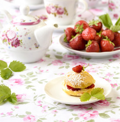 Cream puffs or profiterole filled with whipped cream,g served with strawberries