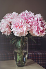 Rich bouquet of pink peonies roses flowers in  vase on table background. Summer time concept. Still life, rustic style. floral, home decor. text, copy space