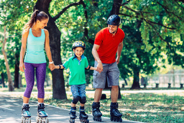 Family with one child roller skating in the park