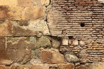 Old red brick masonry and yellow stone slabs background. Cracked old wall of ancient church in Tbilisi, Georgia