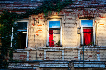 three open windows on brick building in the evening