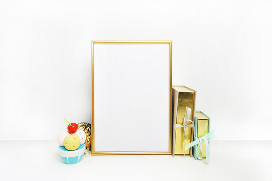 Mockup frame.Gold frame and white wall. Gold book. Ice cream. Poster wall