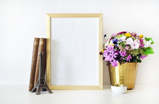Gold frame mock-up, and white wall with gold vase, and flowers. Place work