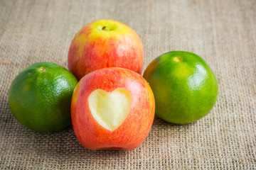 Apple and orange on hemp sack background. Concept Healthy fruit,