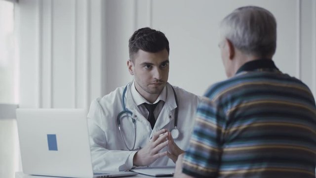 Young Doctor Consults Elderly Patient